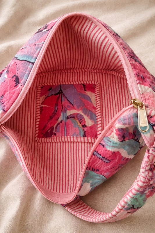 Handmade cross body bag Elara in wildflower pattern, worn casually over the shoulder against a sunny outdoor backdrop.