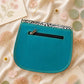 Handmade Leather Crossbody Bag - Romy in a model's hands, showcasing its unique design and vibrant colors against a floral backdrop.