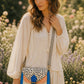 Handmade Leather Crossbody Bag - Romy - Painted Garden - Celeste on a soft background with dried flowers.