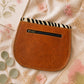 Handmade Leather Crossbody Bag with vibrant colors and zebra print flap on a floral background.