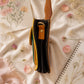 Handmade Leather Crossbody Bag - Romy in yellow and blue, surrounded by flowers and sketchbook.