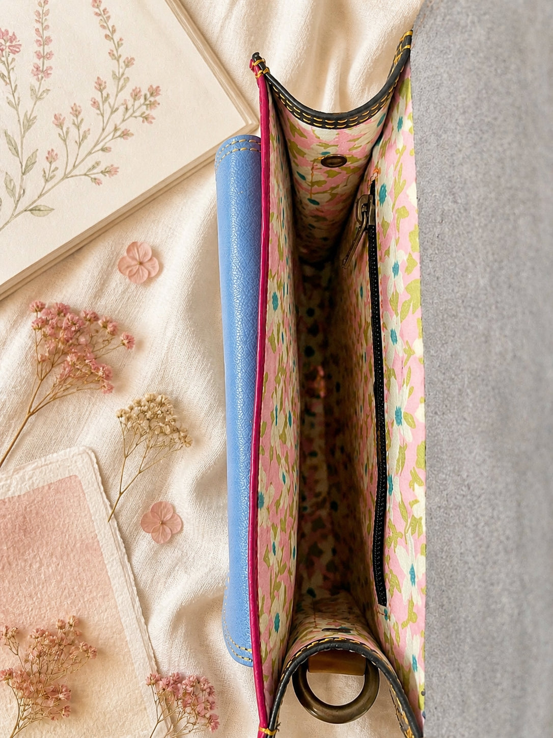 Handmade Leather Crossbody Bag in vibrant fuchsia, blue, and red colors, featuring a stylish buckle detail on a floral background.