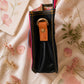 Handmade Leather Crossbody Bag in vibrant fuchsia, blue, and red colors, featuring a stylish buckle detail on a floral background.