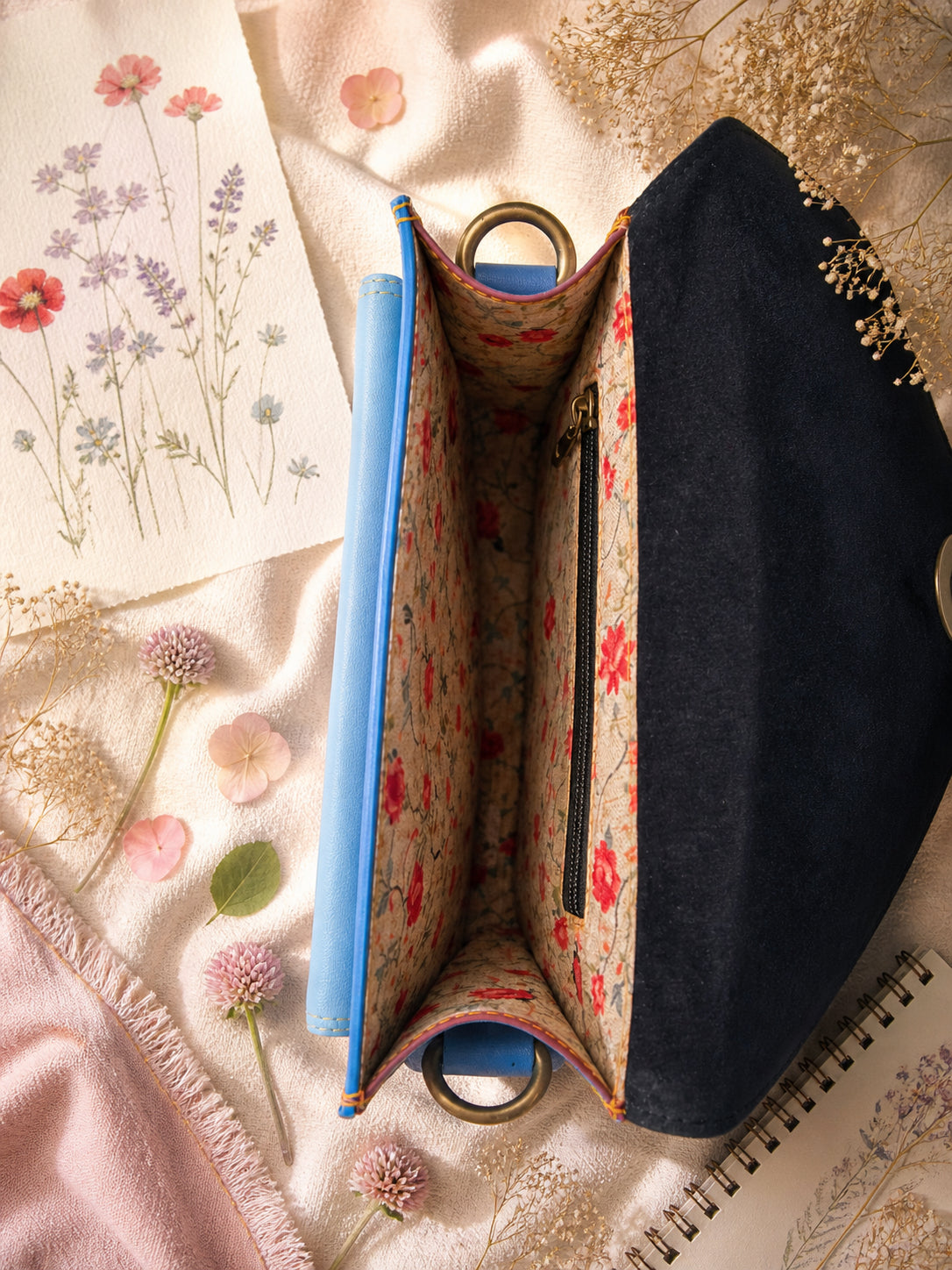 Handmade Leather Crossbody Bag in vibrant colors with pink, blue, and yellow hues, resting on a soft fabric backdrop.