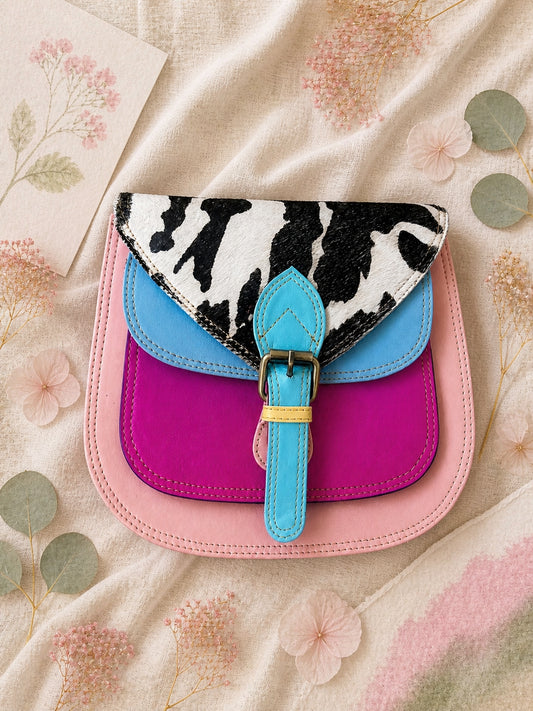 Handmade Leather Crossbody Bag featuring a colorful design with pink, blue, and patterned accents, showcasing unique craftsmanship.