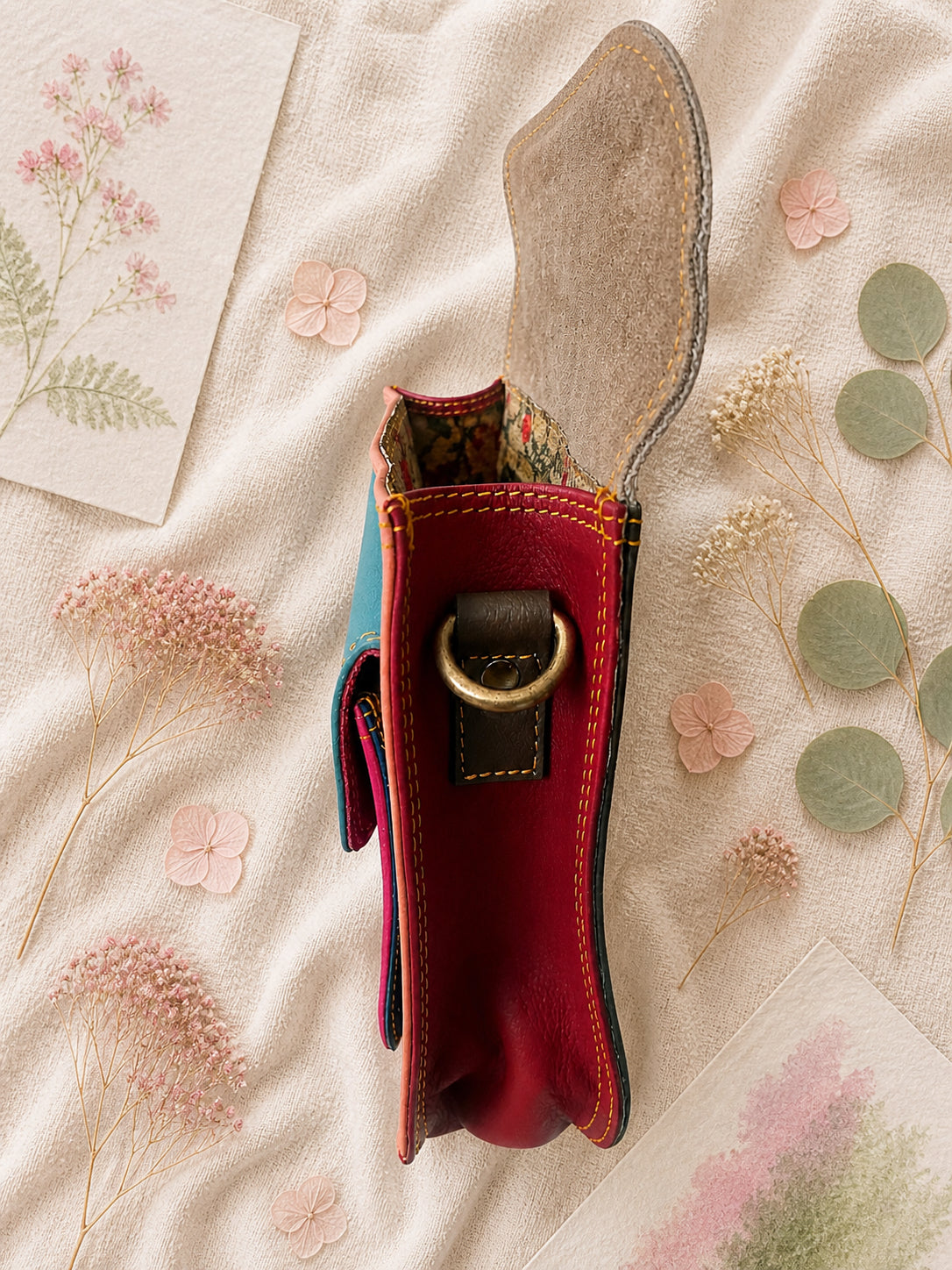 Handmade Leather Crossbody Bag featuring a colorful design with pink, blue, and patterned accents, showcasing unique craftsmanship.