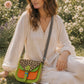 Handmade Leather Crossbody Bag in vibrant colors with leopard print flap on a textured background.