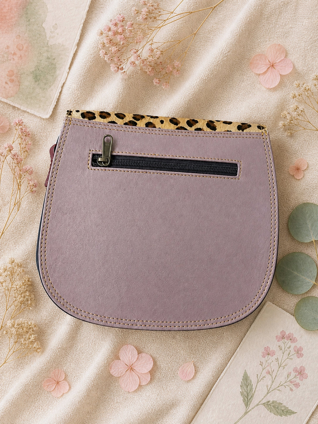 Handmade Leather Crossbody Bag in vibrant colors with leopard print flap on a textured background.