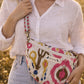 Handmade cross body bag Elara Wildflower Path in noir check worn by woman in a field.