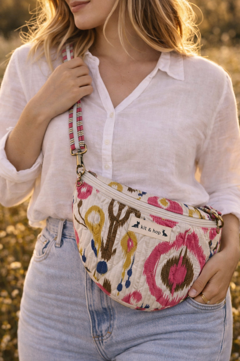 Handmade cross body bag Elara Wildflower Path in noir check worn by woman in a field.