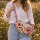 Handmade cross body bag Elara Wildflower Path in noir check worn by woman in a field.