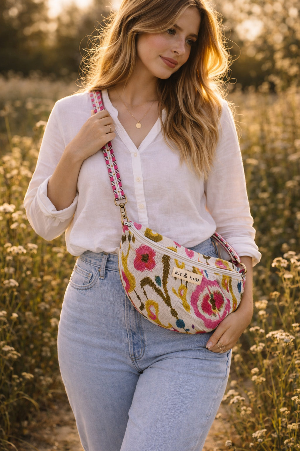 Handmade cross body bag Elara Wildflower Path in noir check worn by woman in a field.