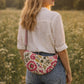 Handmade cross body bag Elara Wildflower Path in noir check worn by woman in a field.