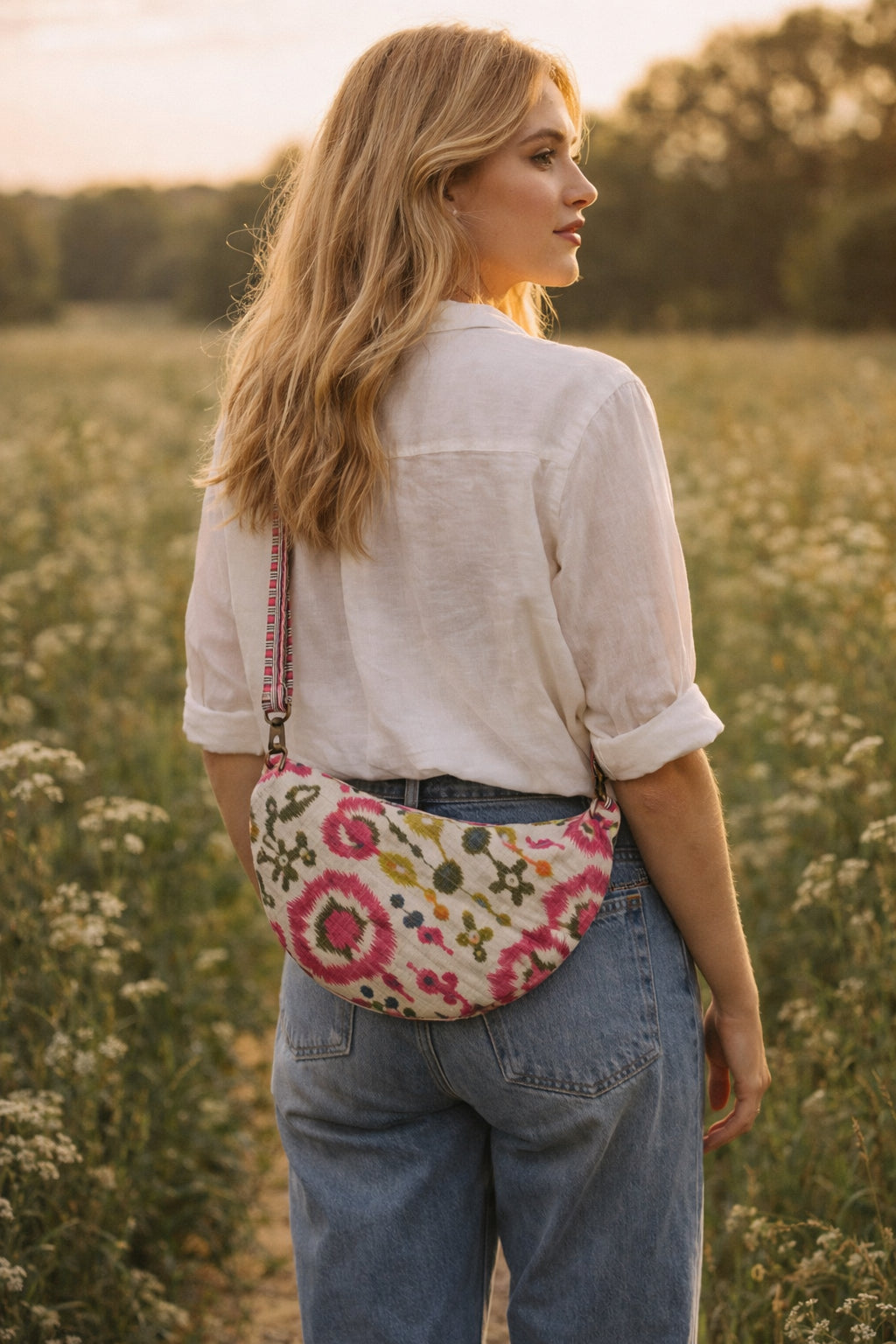 Handmade cross body bag Elara Wildflower Path in noir check worn by woman in a field.