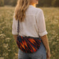 Handmade cross body bag in vibrant colors worn by a woman in a field, showcasing style and comfort.