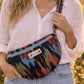 Handmade cross body bag in vibrant colors worn by a woman in a field, showcasing style and comfort.