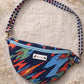Handmade cross body bag in vibrant colors worn by a woman in a field, showcasing style and comfort.
