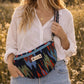 Handmade cross body bag in vibrant colors worn by a woman in a field, showcasing style and comfort.