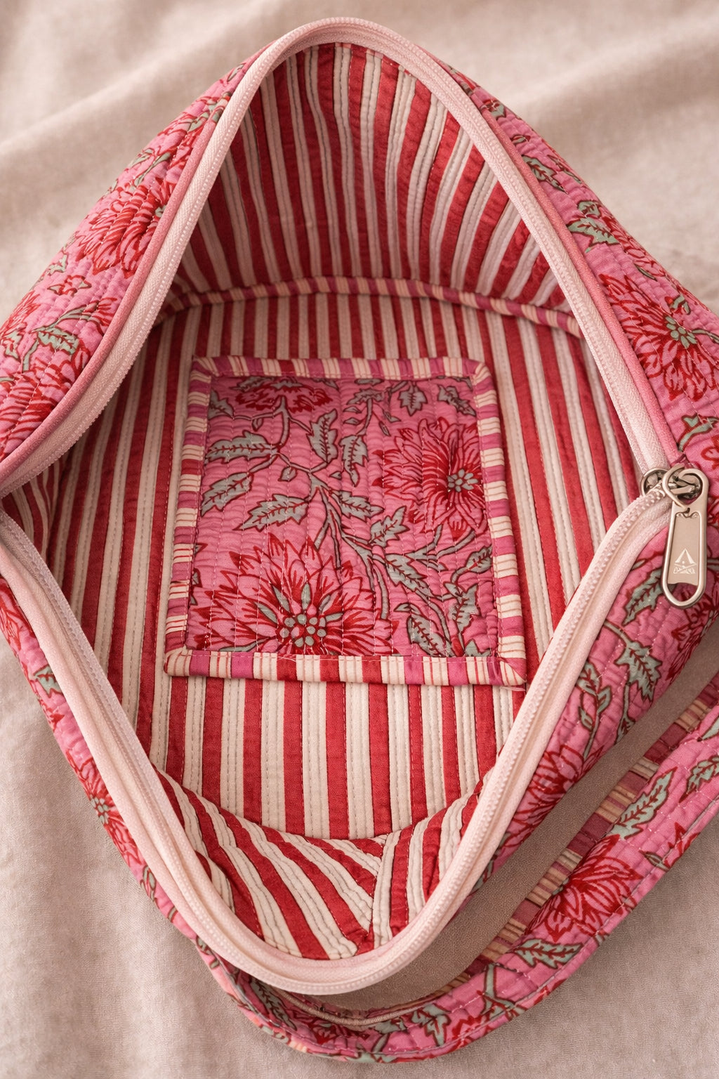 Handmade cross body bag Elara Wildflower Path in PINK FLORAL worn by woman in a field.