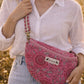 Handmade cross body bag Elara Wildflower Path in PINK FLORAL worn by woman in a field.