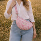 A model wearing the Handmade cross body bag in a wildflower field, showcasing its soft design and adjustable strap.