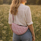 A model wearing the Handmade cross body bag in a wildflower field, showcasing its soft design and adjustable strap.