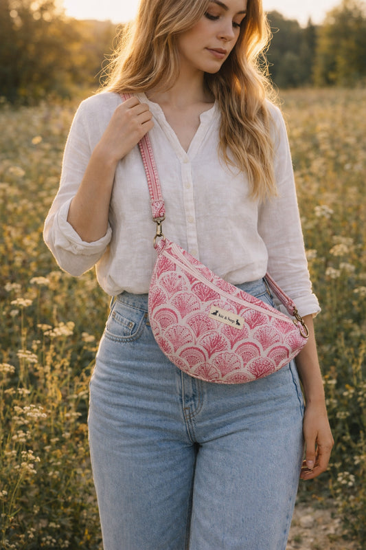 A model wearing the Handmade cross body bag in a wildflower field, showcasing its soft design and adjustable strap.