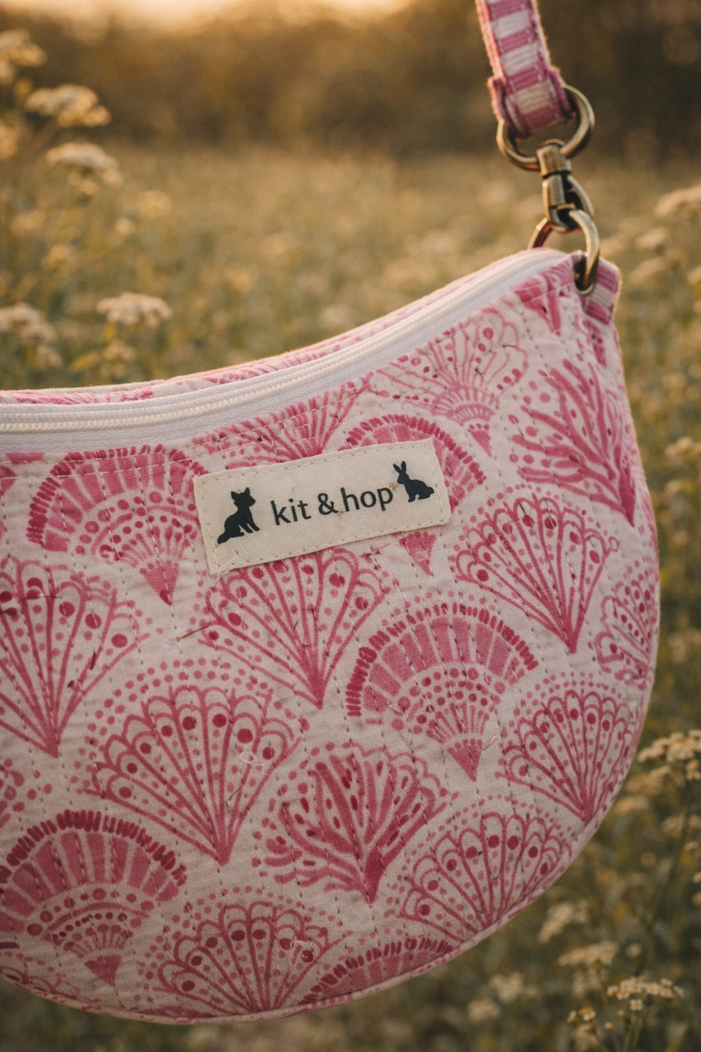 A model wearing the Handmade cross body bag in a wildflower field, showcasing its soft design and adjustable strap.