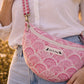 A model wearing the Handmade cross body bag in a wildflower field, showcasing its soft design and adjustable strap.