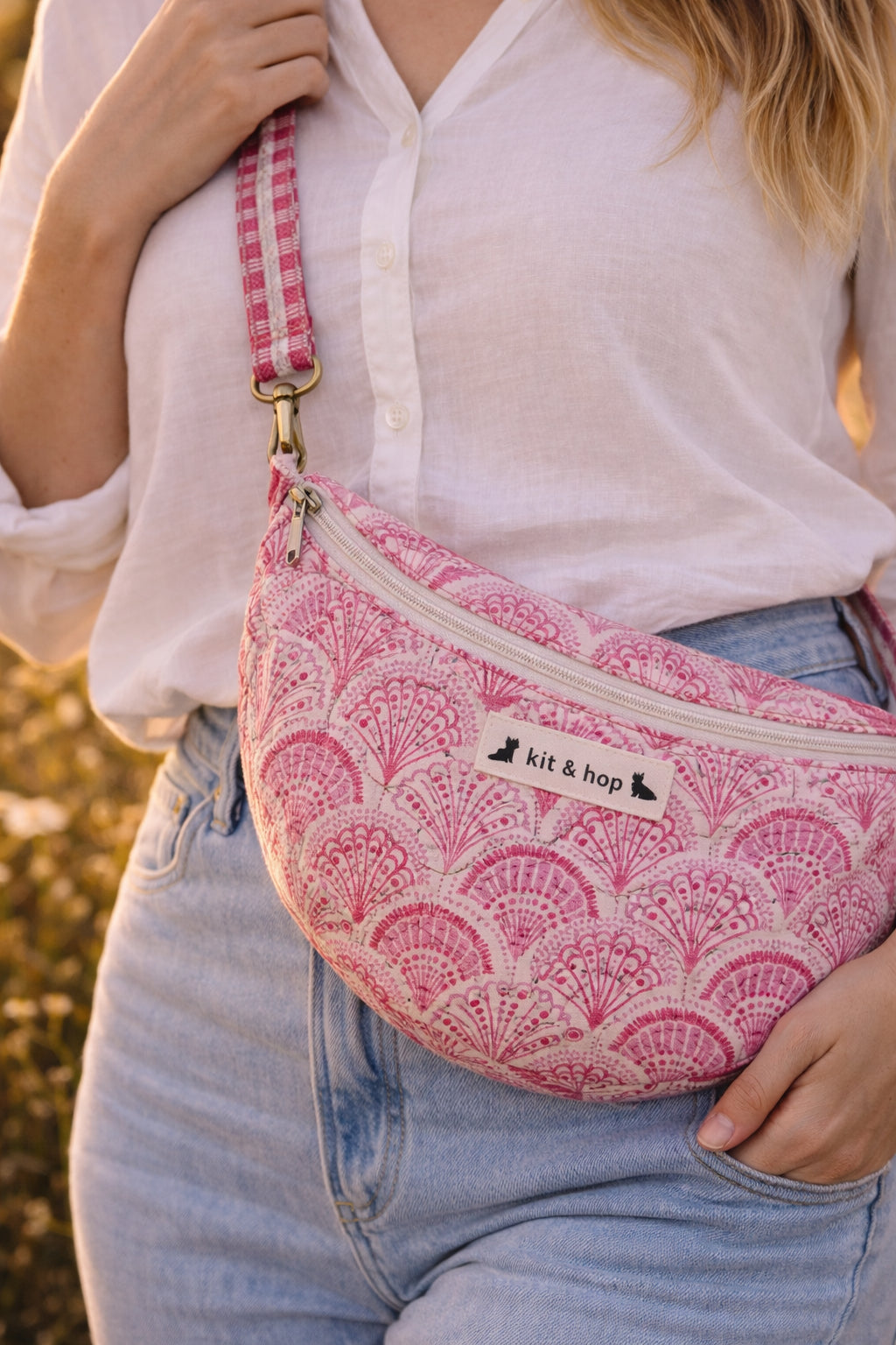 A model wearing the Handmade cross body bag in a wildflower field, showcasing its soft design and adjustable strap.