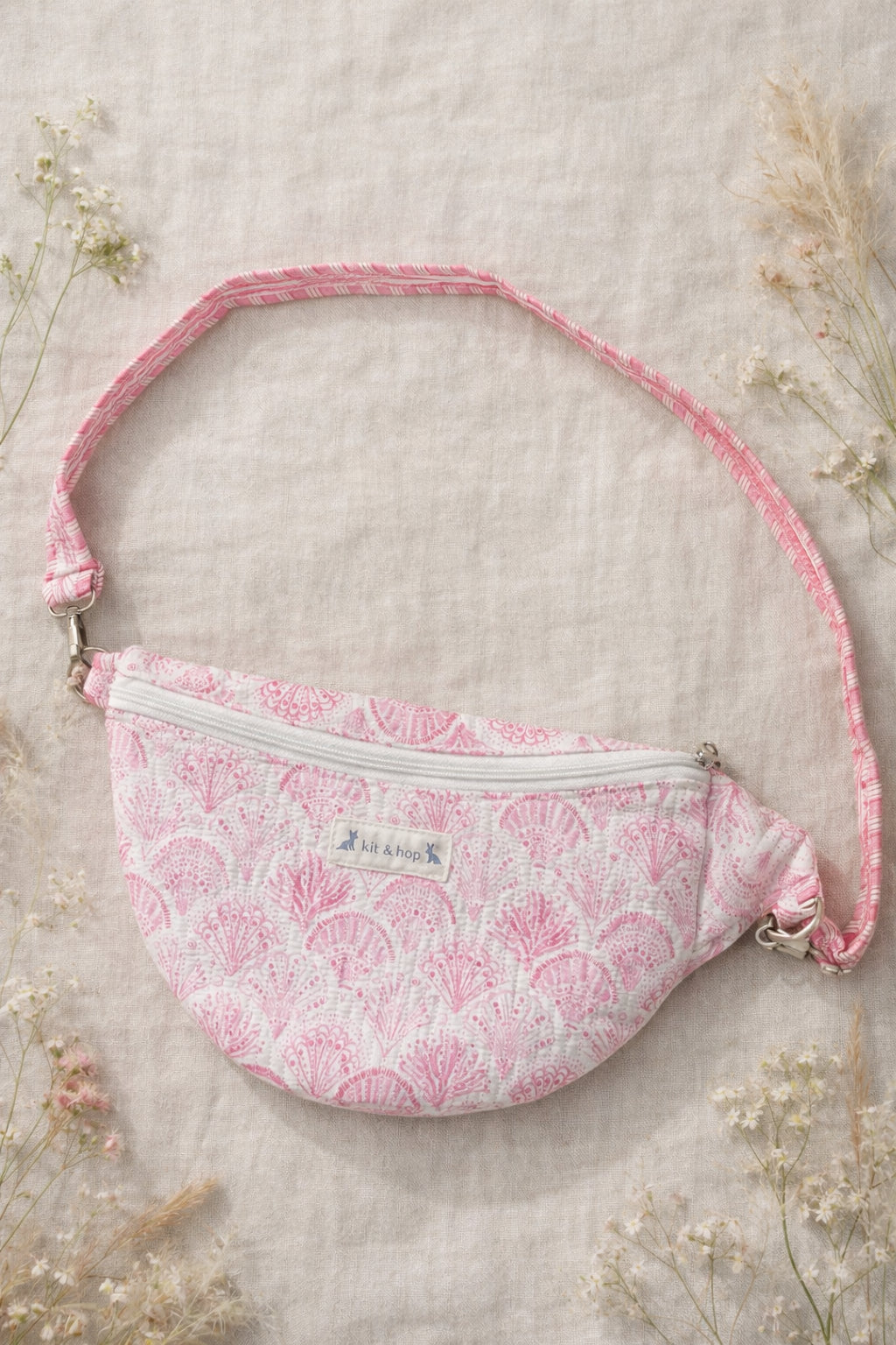 A model wearing the Handmade cross body bag in a wildflower field, showcasing its soft design and adjustable strap.