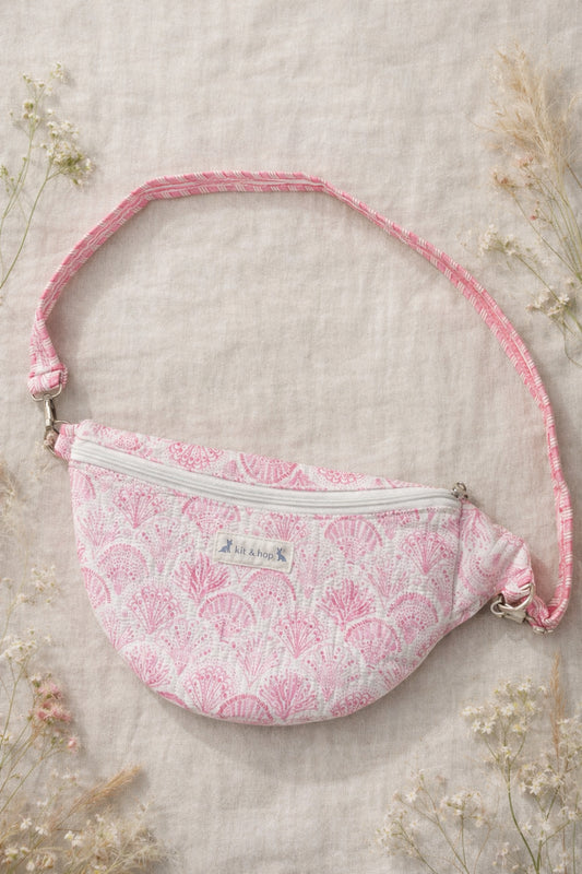 A model wearing the Handmade cross body bag in a wildflower field, showcasing its soft design and adjustable strap.