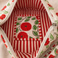Handmade cross body bag Elara in Poppy pattern, worn by a woman in a field, perfect for everyday use.