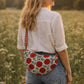 Handmade cross body bag Elara in Poppy pattern, worn by a woman in a field, perfect for everyday use.
