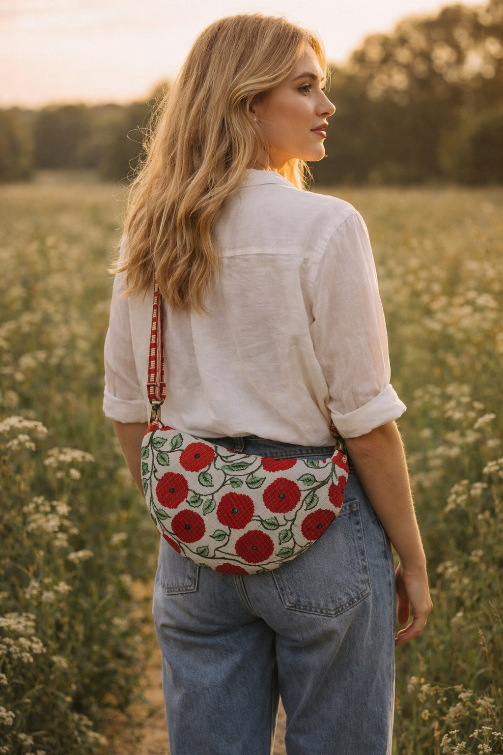 Handmade cross body bag Elara in Poppy pattern, worn by a woman in a field, perfect for everyday use.