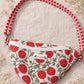 Handmade cross body bag Elara in Poppy pattern, worn by a woman in a field, perfect for everyday use.