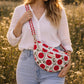 Handmade cross body bag Elara in Poppy pattern, worn by a woman in a field, perfect for everyday use.
