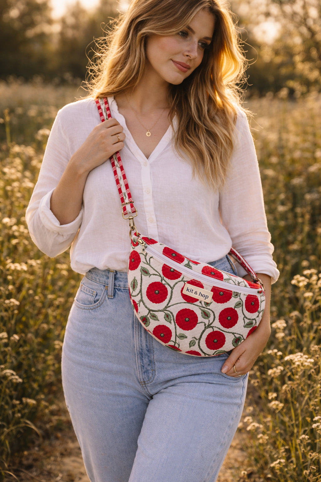 Handmade cross body bag Elara in Poppy pattern, worn by a woman in a field, perfect for everyday use.