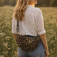 Handmade cross body bag Elara Wildflower Path in LEOPARD PRINT worn by woman in a field.