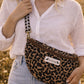 Handmade cross body bag Elara Wildflower Path in LEOPARD PRINT worn by woman in a field.