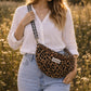 Handmade cross body bag Elara Wildflower Path in LEOPARD PRINT worn by woman in a field.