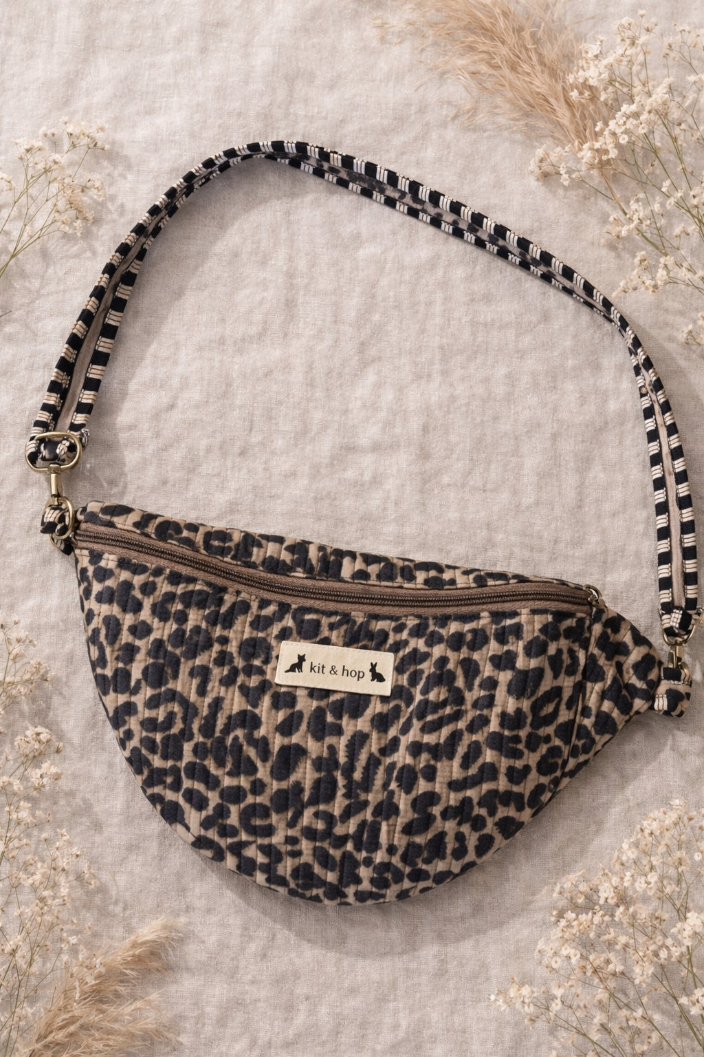 Handmade cross body bag Elara Wildflower Path in LEOPARD PRINT worn by woman in a field.