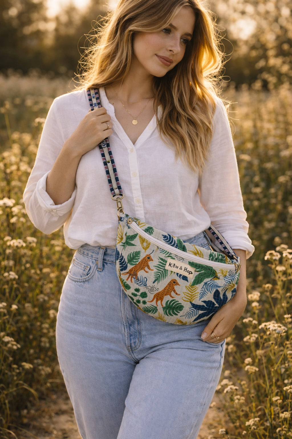Handmade cross body bag Elara Wildflower Path in ANIMAL PRINT worn by woman in a field.