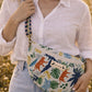 Handmade cross body bag Elara Wildflower Path in ANIMAL PRINT worn by woman in a field.
