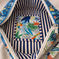 Handmade cross body bag Elara Wildflower Path in ANIMAL PRINT worn by woman in a field.