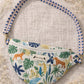Handmade cross body bag Elara Wildflower Path in ANIMAL PRINT worn by woman in a field.