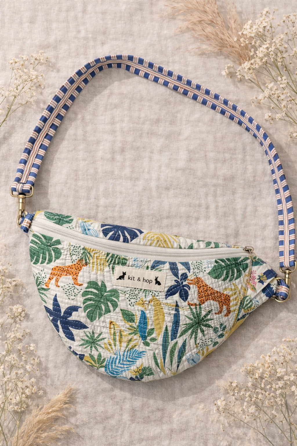 Handmade cross body bag Elara Wildflower Path in ANIMAL PRINT worn by woman in a field.