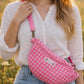 Handmade cross body bag Elara in pink gingham worn by a woman outdoors in a sunny field.