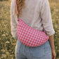 Handmade cross body bag Elara in pink gingham worn by a woman outdoors in a sunny field.