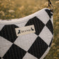 Handmade cross body bag Elara Wildflower Path in noir check worn by woman in a field.